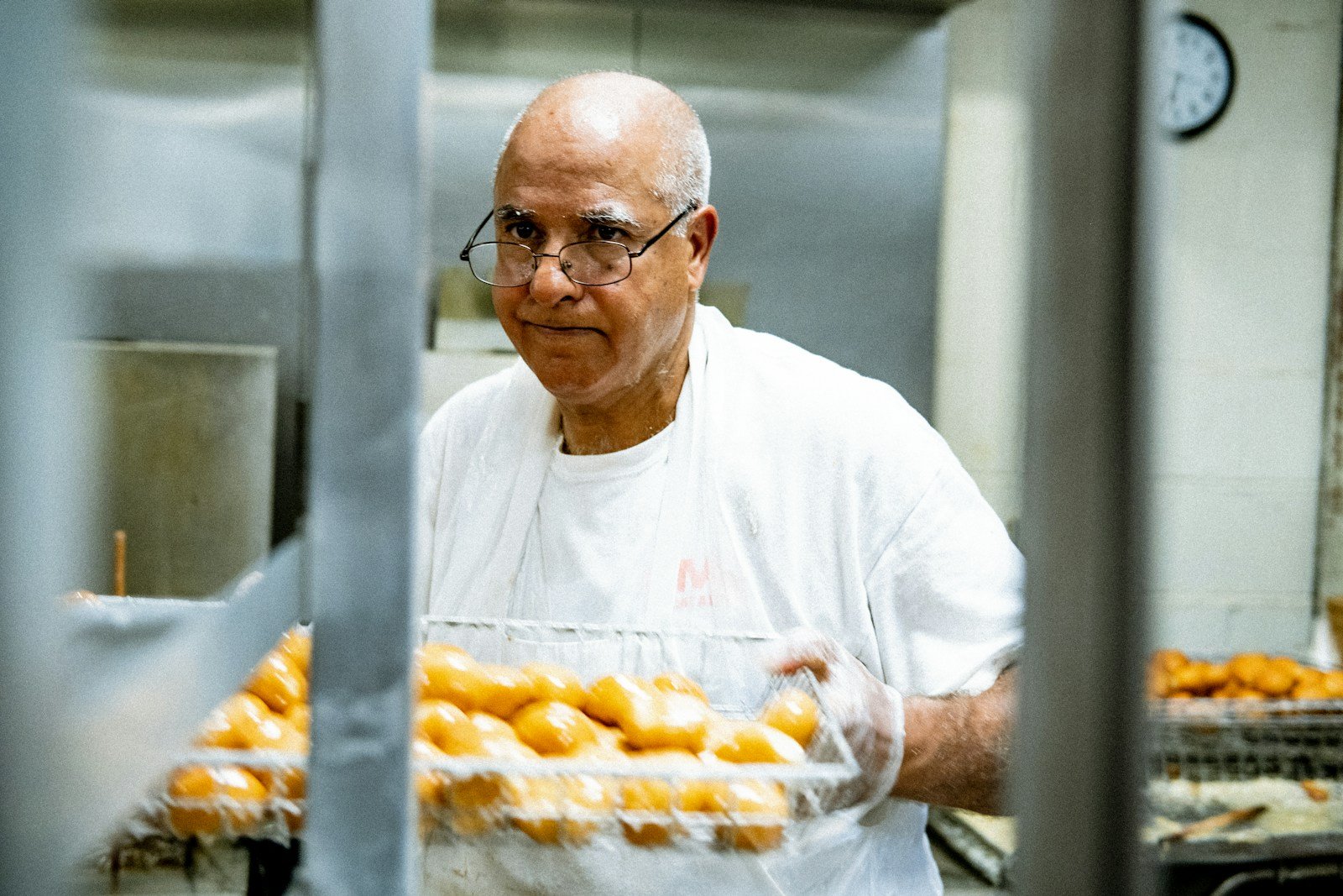 Boulanger portant une plaque de viennoiseries sortie du four