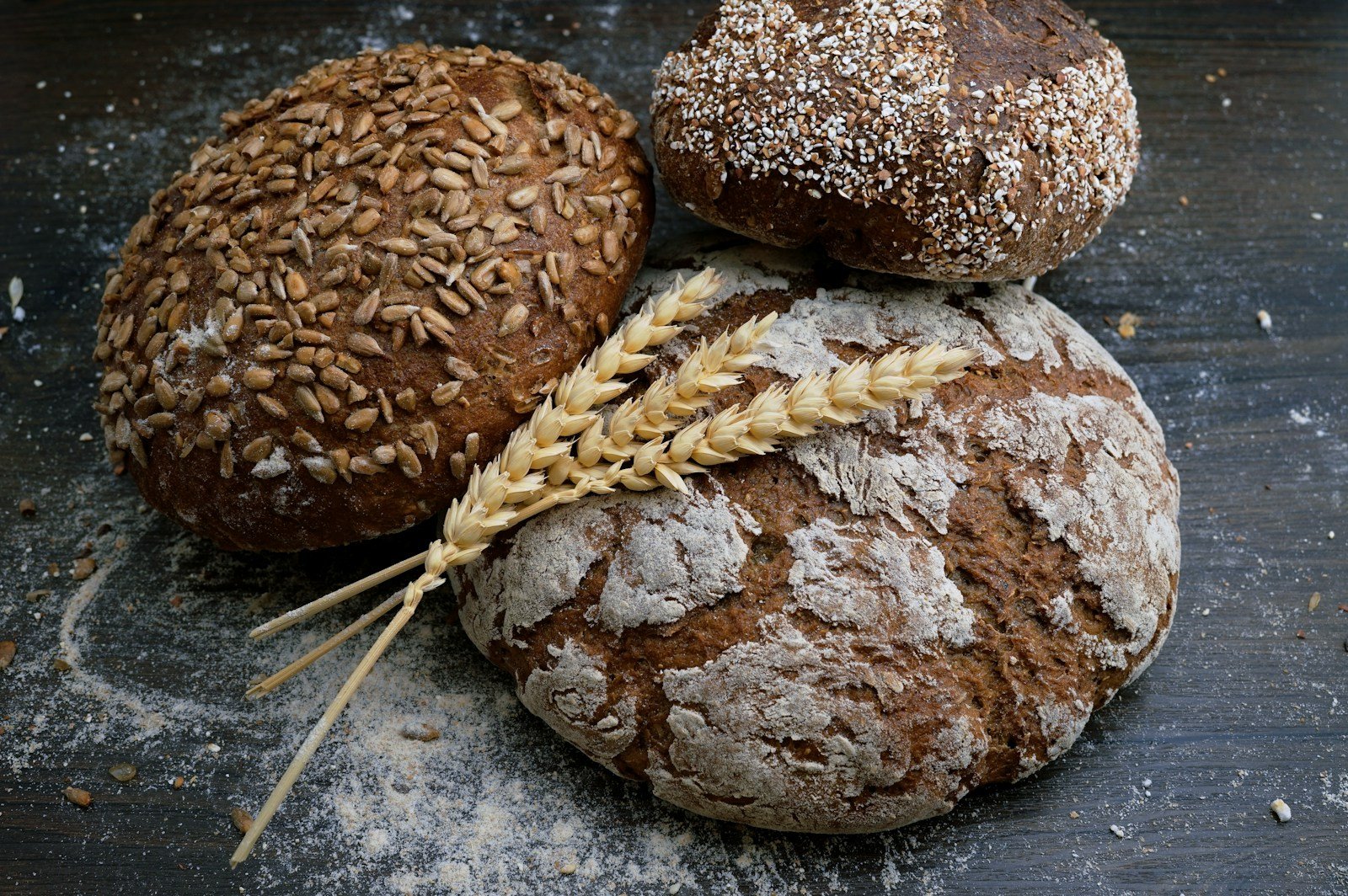 Farine de blé et farine de seigle côte à côte dans des bols, sur un plan de travail de boulanger