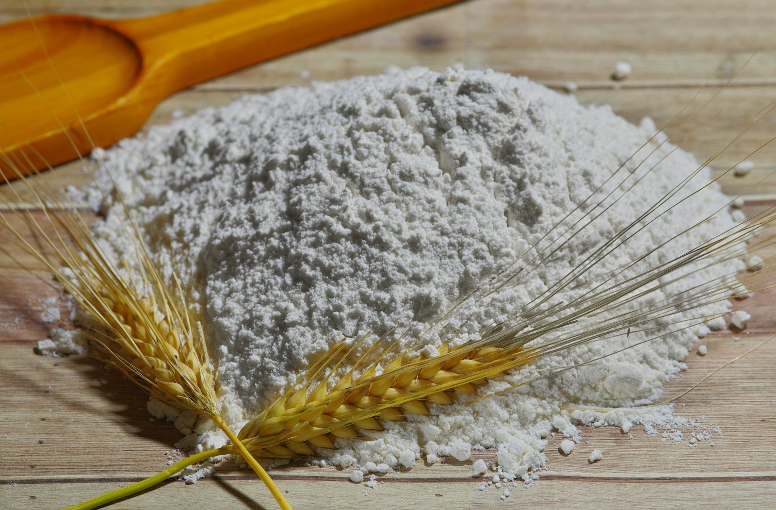 Farine de blé et grains de blé posés sur un plan de travail