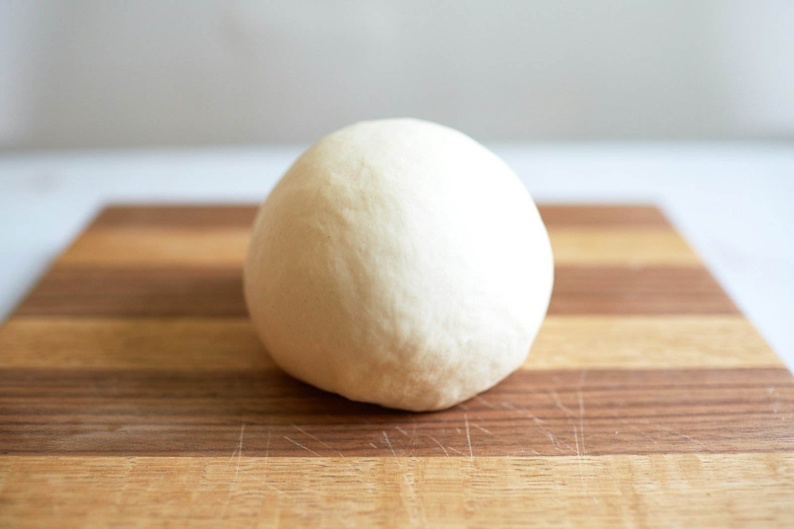 Levain dur en boule ferme posé à côté d'un levain liquide dans un bocal