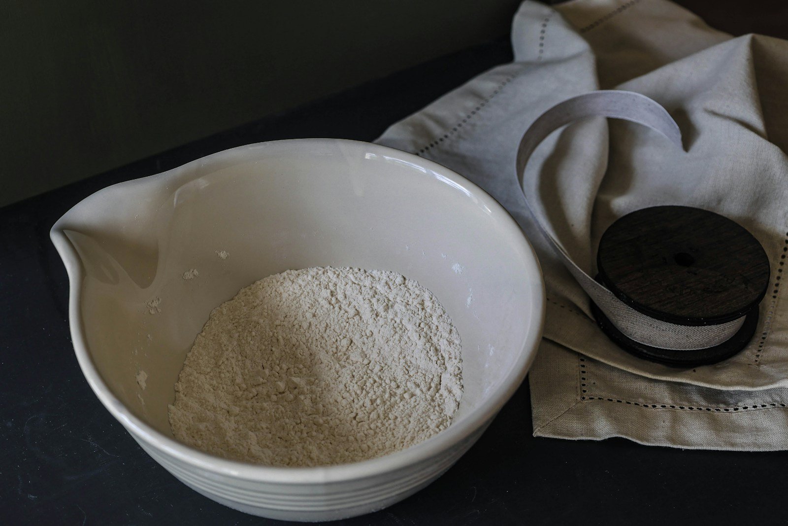 Levain liquide dans un bocal, farine et balance de cuisine sur un plan de travail