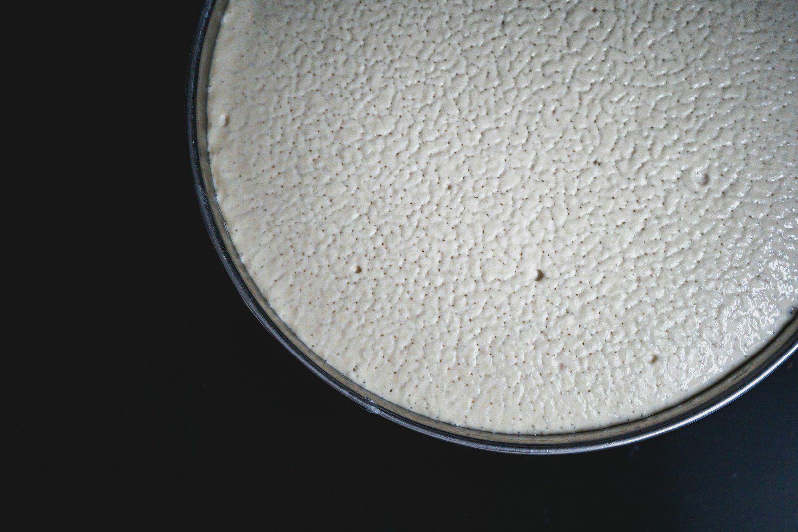 Levain naturel en fermentation dans un bocal en verre, bulles visibles à travers la paroi