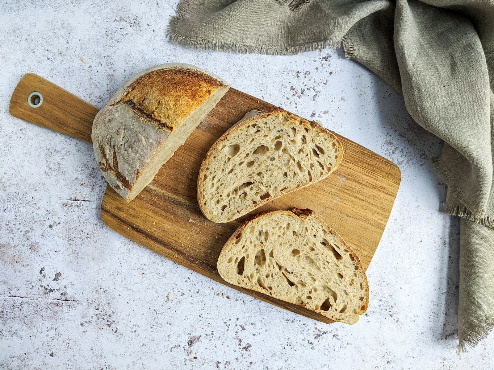 Miche de pain au levain posée sur une planche de bois Miche de pain au levain posée sur une planche de bois