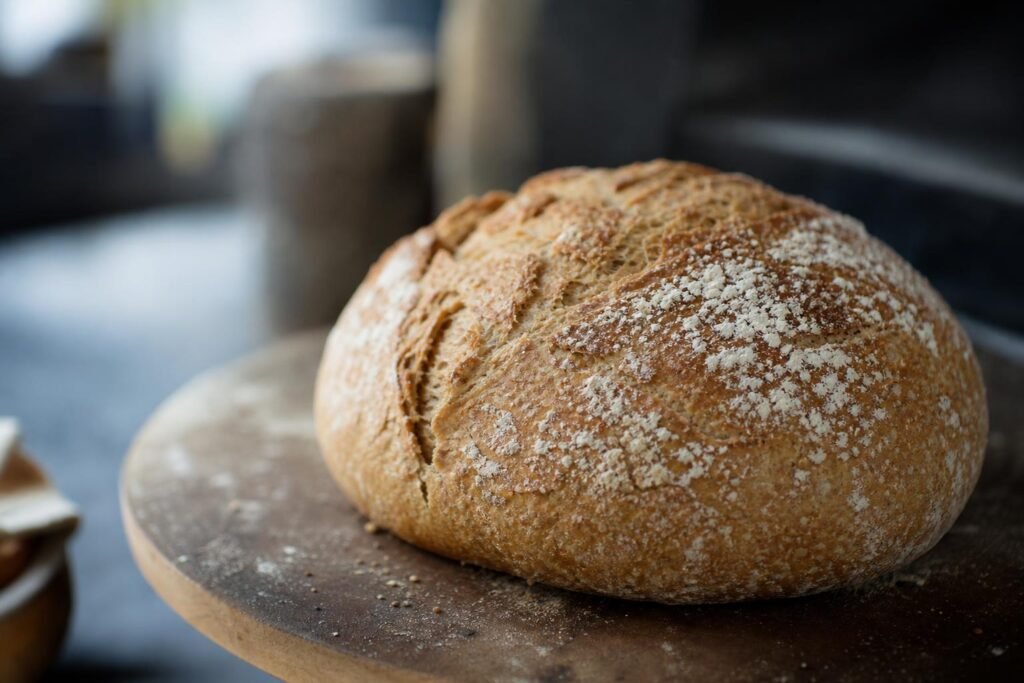 Pain complet maison en boule, à la farine intégrale T150, posé sur une pierre à four