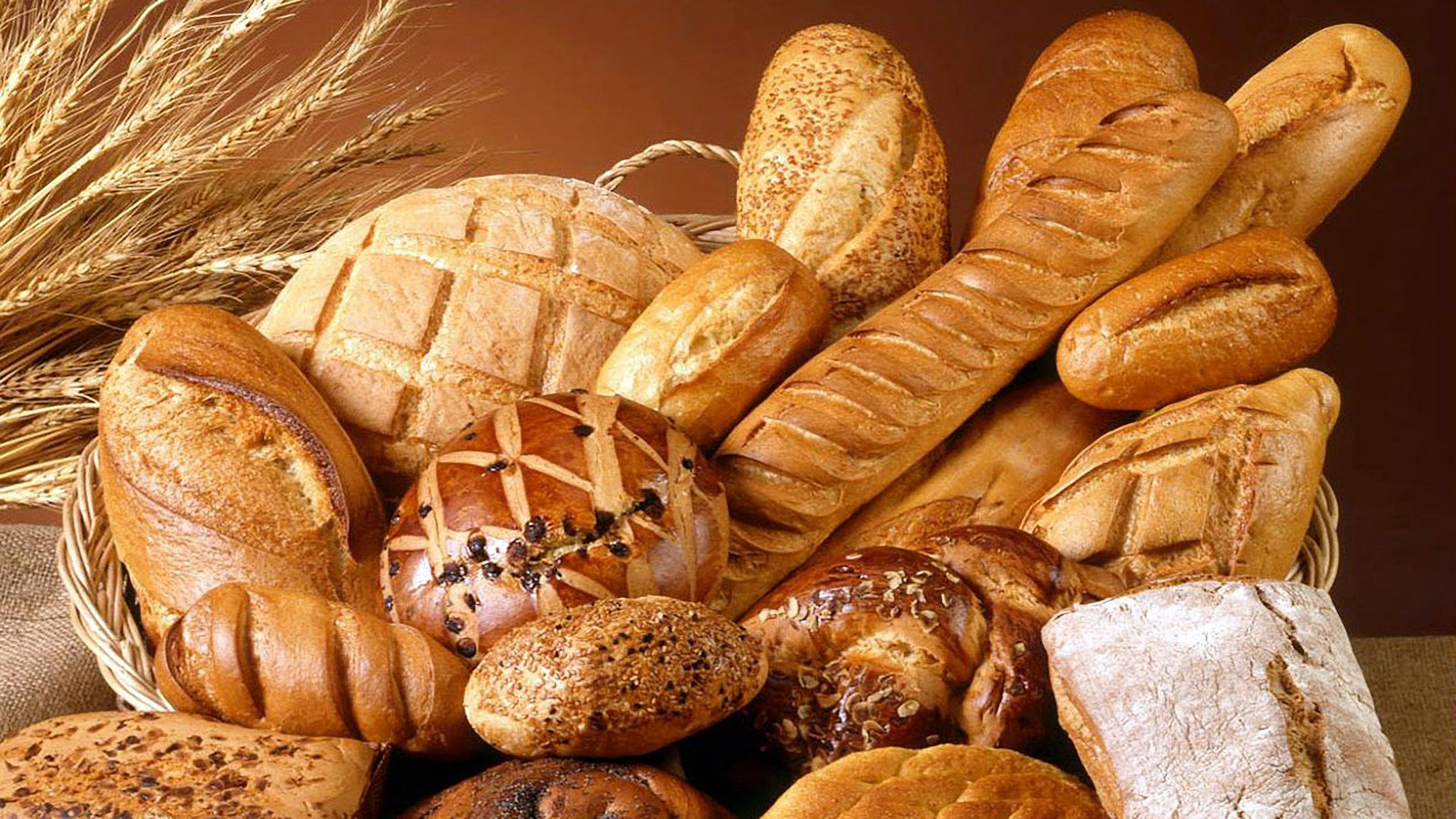 Plusieurs pains à sandwich alignés sur une planche de bois