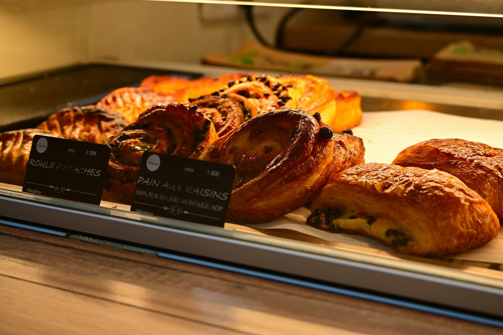 Pains aux raisins garnis de crème pâtissière en vitrine de boulangerie