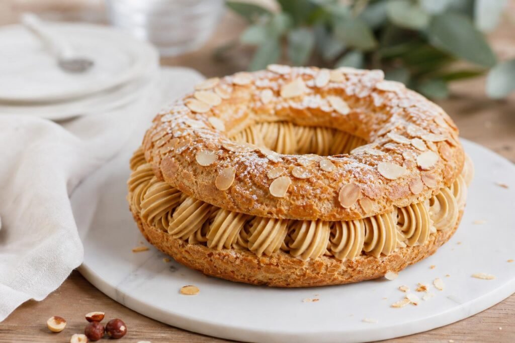 Paris-Brest maison en couronne, garni de crème pralinée et parsemé d'amandes effilées