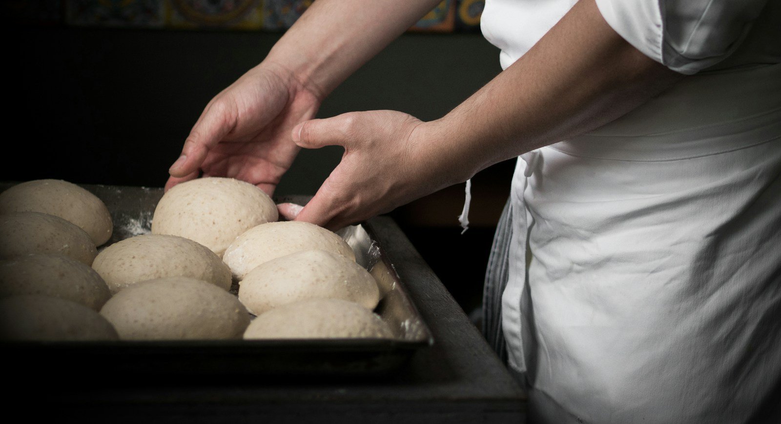 Pâtons boulés et légèrement aplatis sur une plaque avant l'apprêt