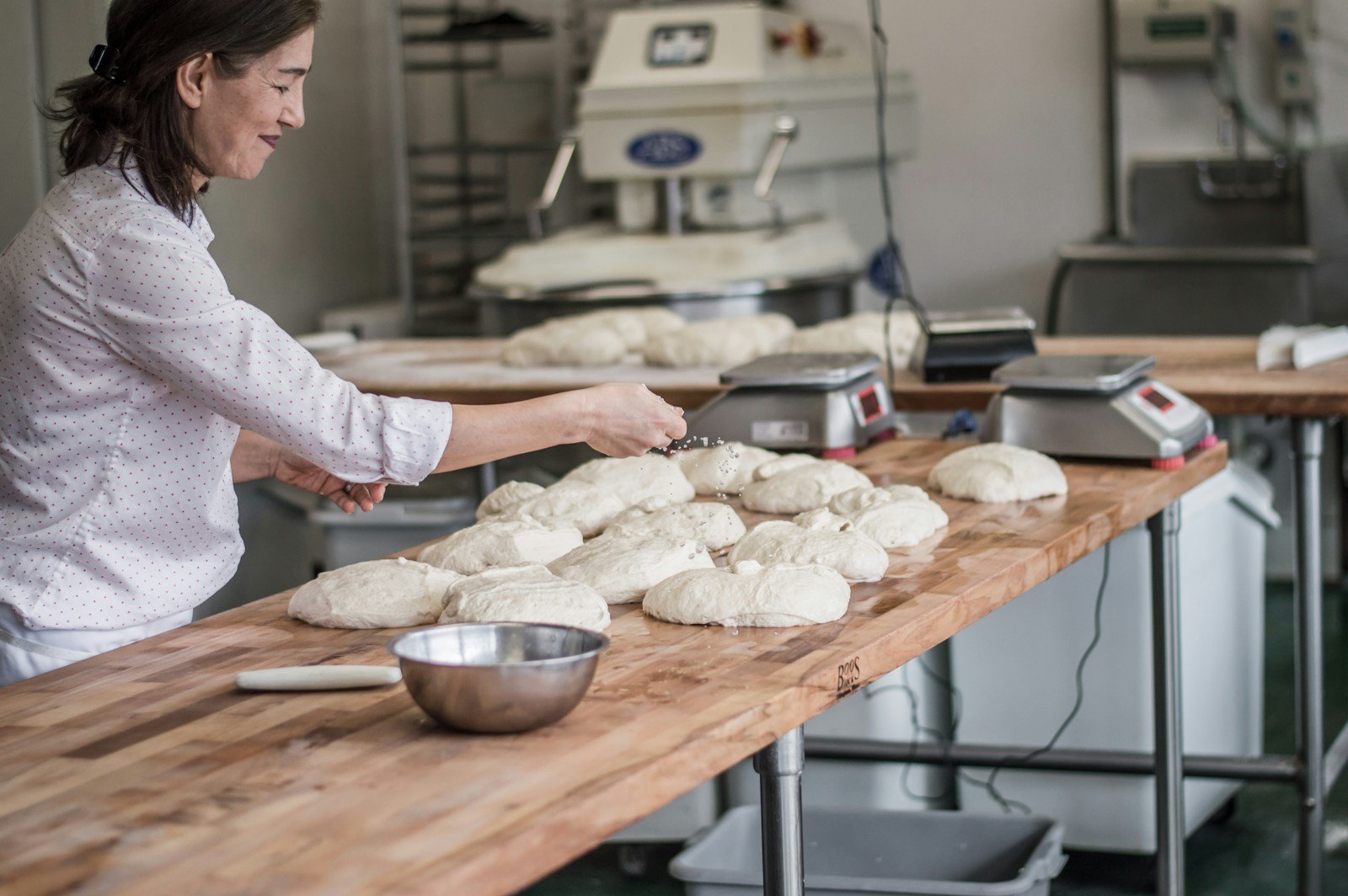 Un boulanger pèse sa farine sur une balance de fournil